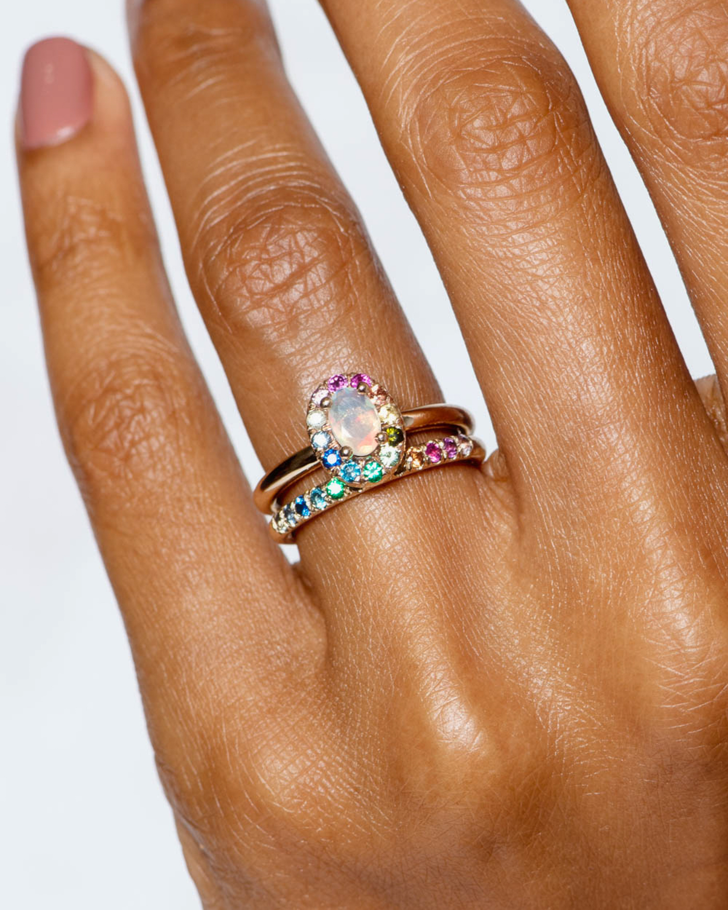 10_year_halo_on_figure_dez_opal_with_rainbow_ring_and_dez_half_eternity_round_rainbow_band_1_crop_7.jpg