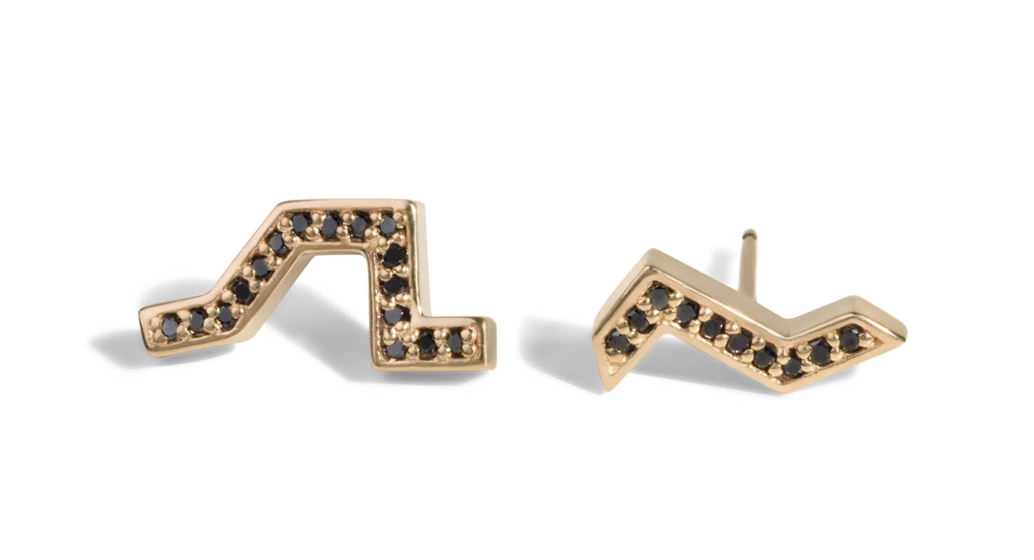 A pair of asymmetrical studs adorned with striking black diamonds