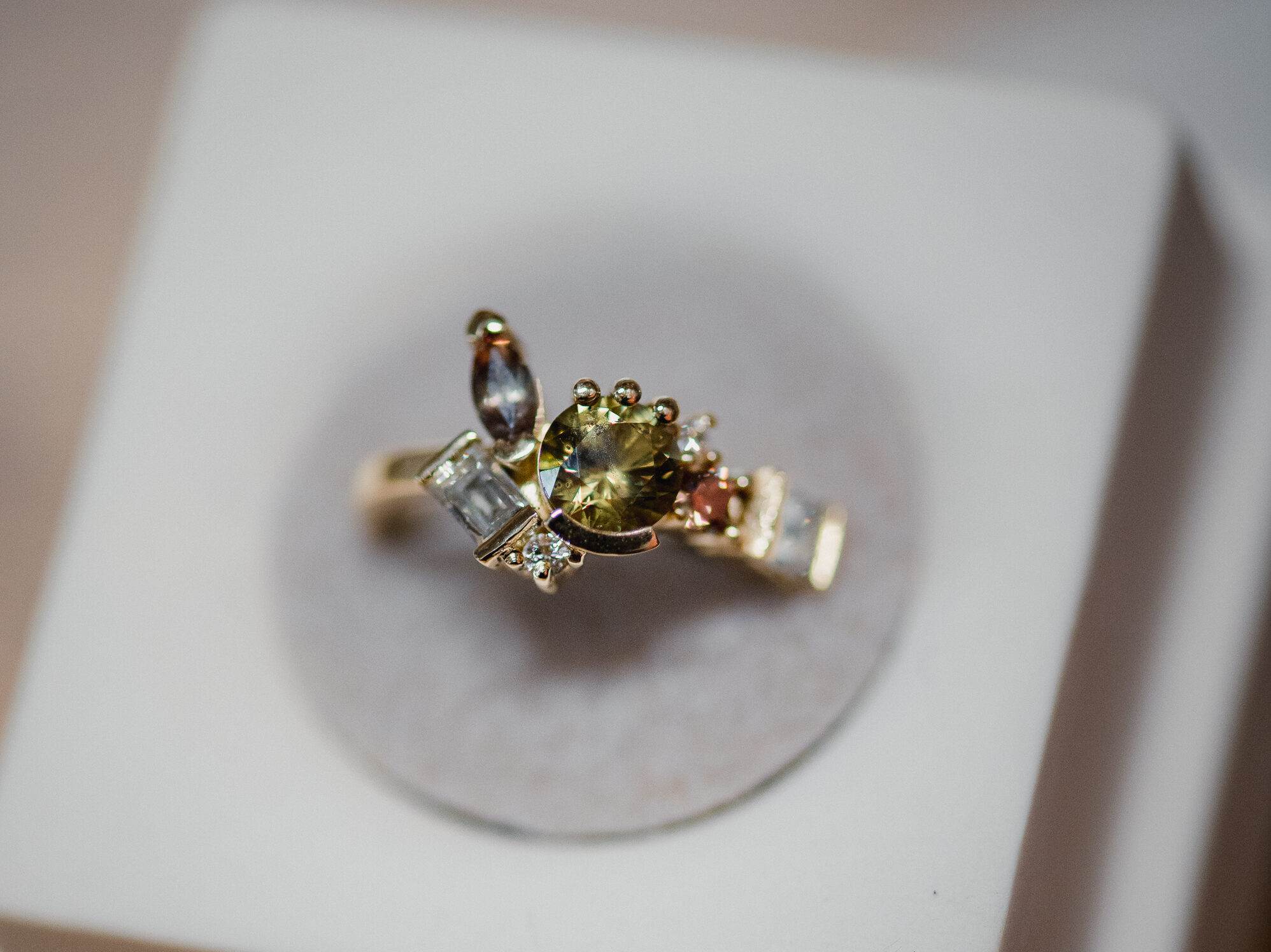 Custom heirloom ring in focus sitting in a porcelain ring box